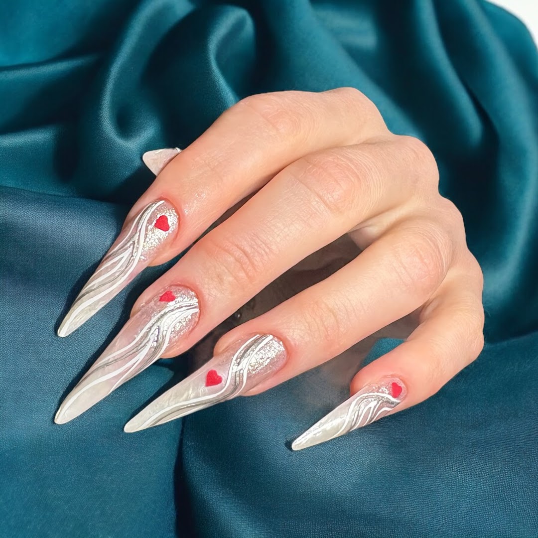 Lange nagels met sierlijke witte nail art op diepgroen satijn